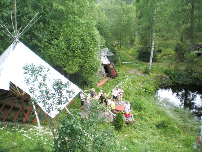 Teuvo Zettermanin ryhmä ihailee Lummelammen maisemaa ateljeen amfiteatterin esiintymislavalta. Vasemmalla katettu amfiteatteri ja taustalla Lapin Taidekodan ovi kutsuvasti avoinna.