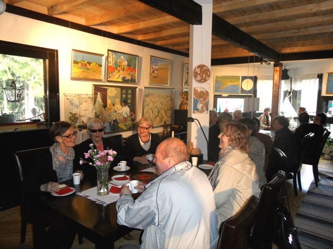 Käkisalmen kaupungin Rouvasväen yhdistyksen retkeläiset nauttivat karjalanpiirakka-kahvit ateljeen näyttelygalleriassa. Kuvassa vasemmalla pj. Leena Lindgren