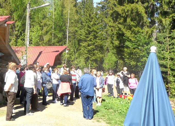 Kelan ryhmäretkeläiset saapumassa tutustumaan Villa Vesperiin. Taiteilija toivottaa vieraat tervetulleiksi.